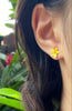 a pair of petite sunny yellow dendrobium orchid stud earrings in rose gold plating on ear from forest jewelry singapore
