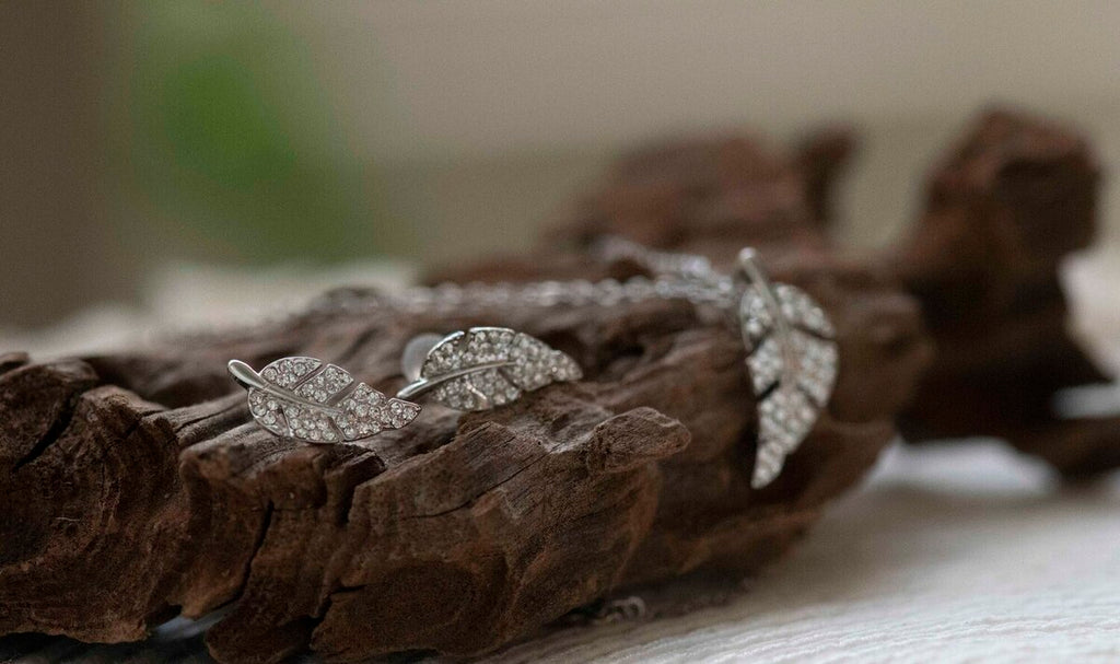 leaf shape stud earrings with crystals and pendant in rhodium plating on wood from forest jewelry