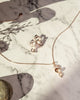 aurora pendant and aurora earrings in rose gold on marble background with stone from forest jewelry singapore