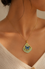 Necklace with a butterfly pendant on a person wearing a beige top.