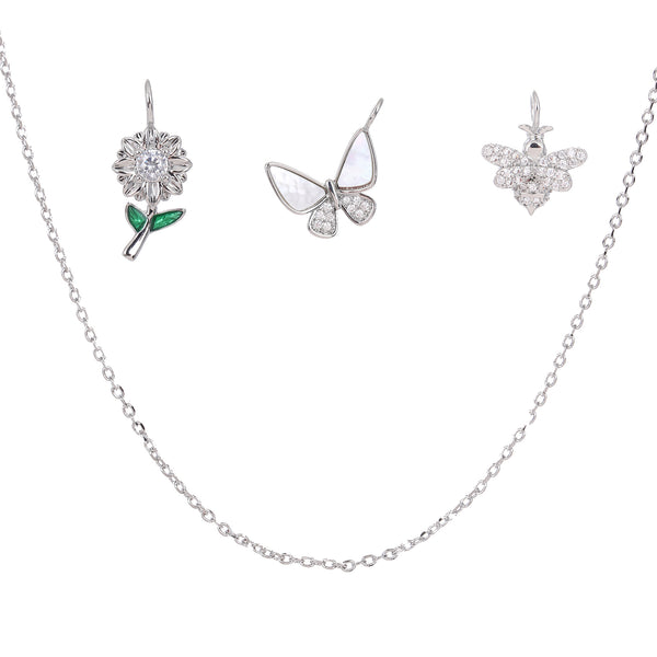 Silver jewelry set with necklace floral, butterfly and bee charms on a white background