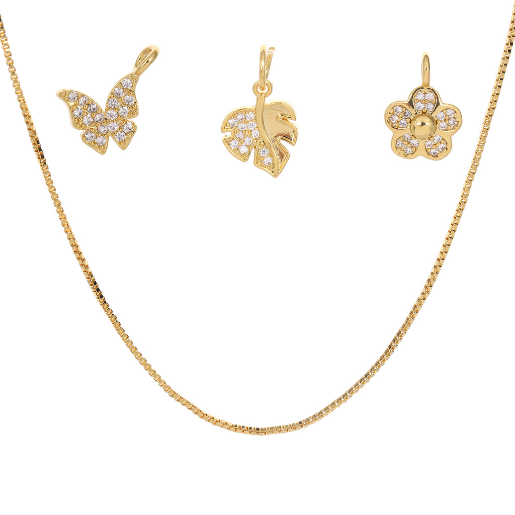Gold jewelry set with butterfly and floral charms on a white background