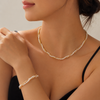 Pearl necklace and bracelet on a model against a neutral background