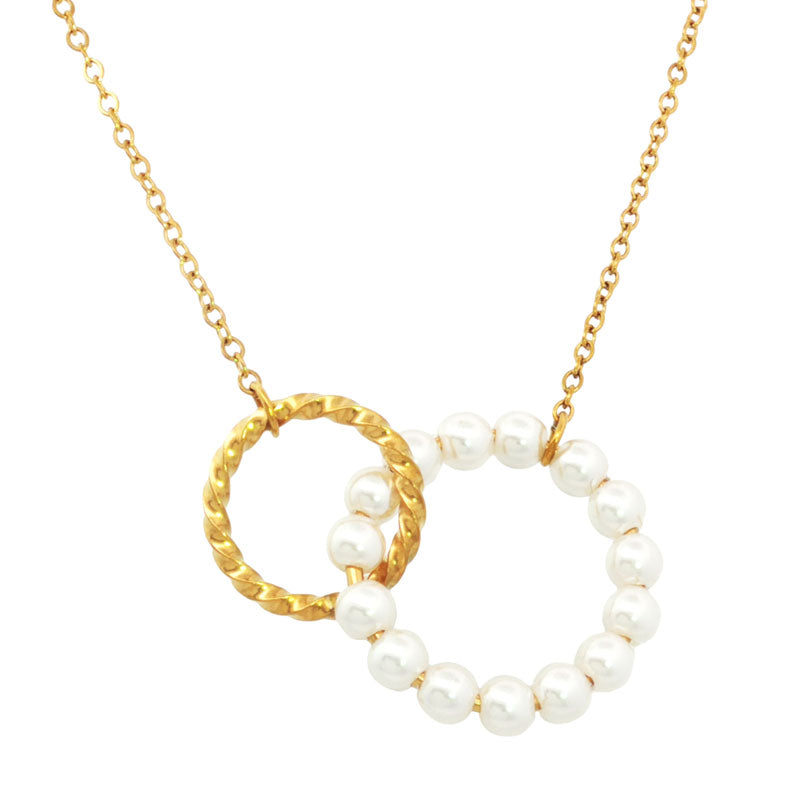 Gold necklace with a heart-shaped pendant featuring pearl inspired beads on a white background