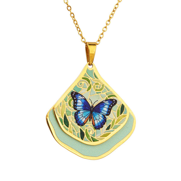 Gold necklace with a blue butterfly pendant on a white background