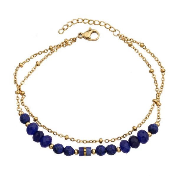 Gold bracelet with blue sodalite on a white background