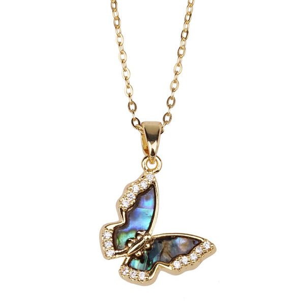 Butterfly-shaped pendant with abalone shell and crystals on a gold chain against a white background
