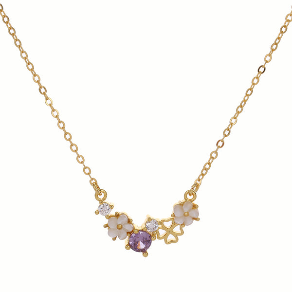 Gold necklace with floral and shell details on a white background