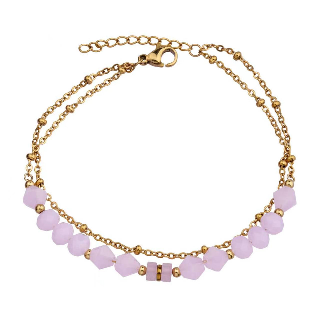 Gold bracelet with pink crystals on a white background