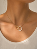Gold necklace with a  simulated pearl pendant worn by a person