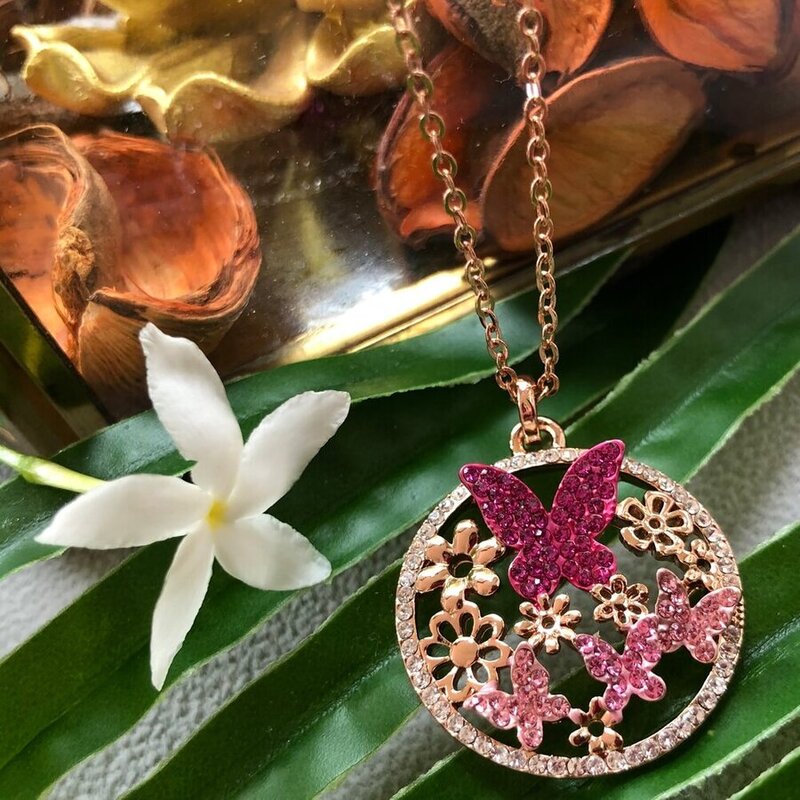 necklace pendant in rose gold plating with butterfly and flowers garden in pink and clear crystals from forest jewelry on leaf
