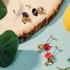 dangling gold plated flora flower earrings on table form forest jewelry singapore