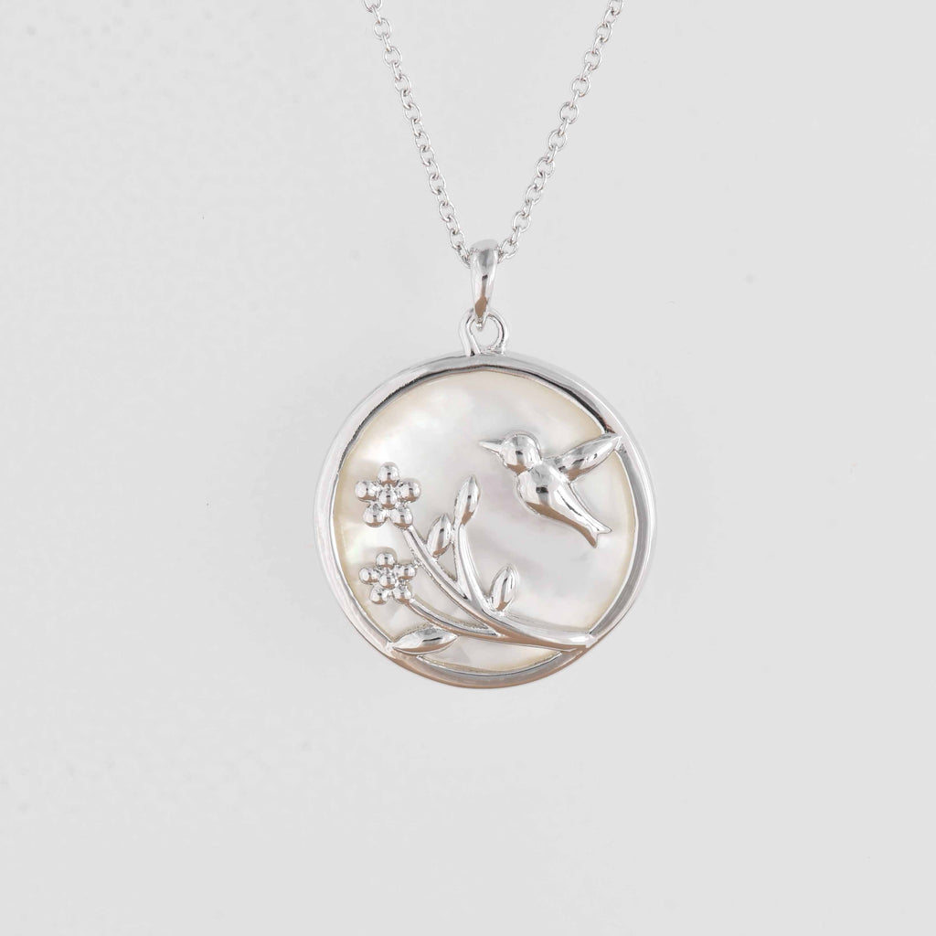 rhodium pendant with sunbird and flower capsuled in mother of pearl from forest jewelry